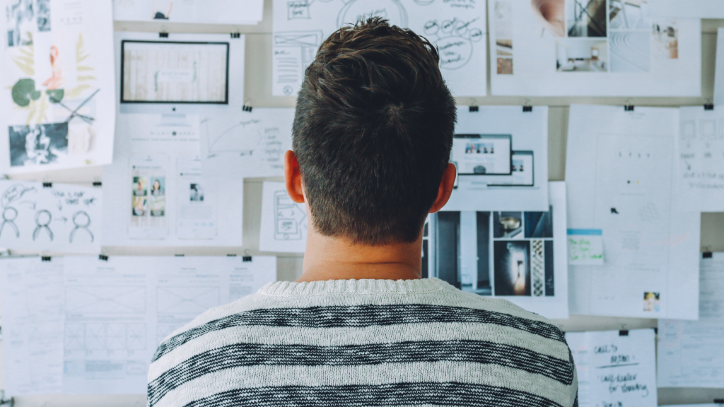 entrepreneur looking at board filled with papers